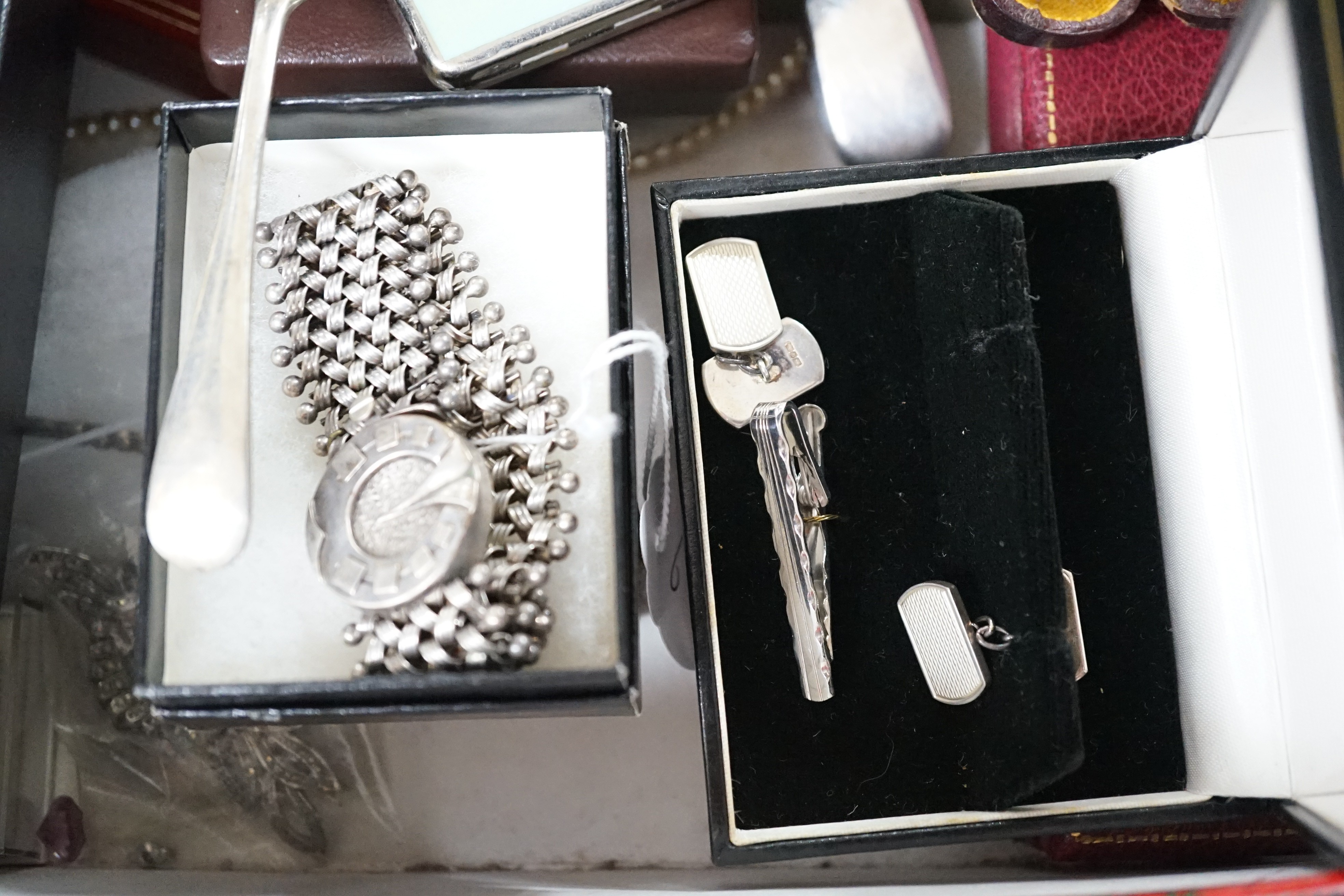 A collection of assorted jewellery including costume, silver and enamel flower head brooch, silver mounted amber cigarette holder, plated flatware, necklaces, commemorative coin, Victorian silver locket, white metal brac